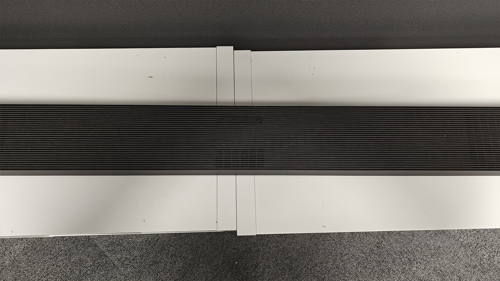 Samsung HW-QS90H Dolby Atmos soundbar on white shelving unit viewed from above