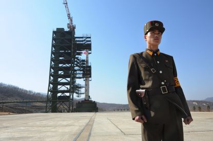 A North Korean soldier stands guard in front of an Unha-3 rocket at the Sohae Satellite Launch Station in Tongchang-Ri on April 8, 2012. 