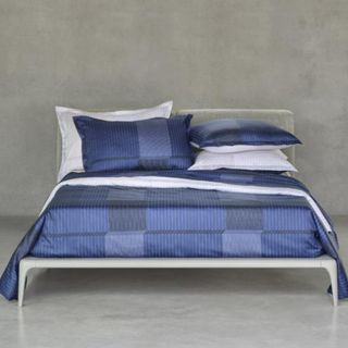 Tennis Stripe Bed Linen on a bed against a gray wall.