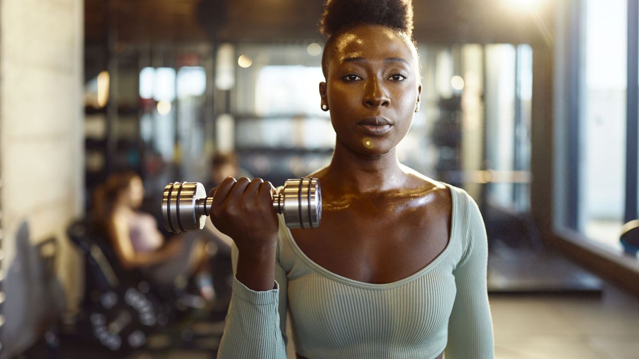 A woman doing a bicep curl at the gym