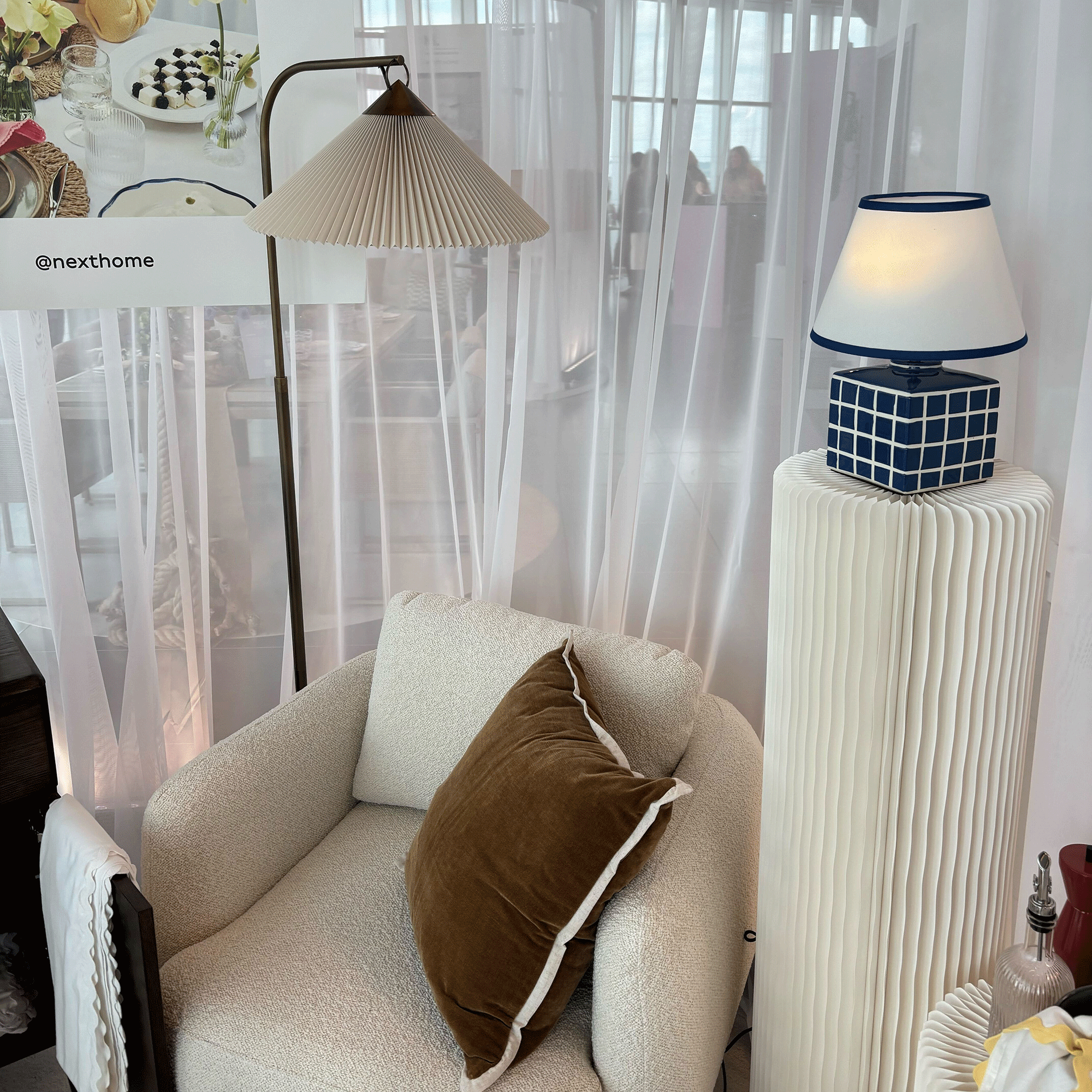 White armchair with blue lamp and brass floor lamp at Next