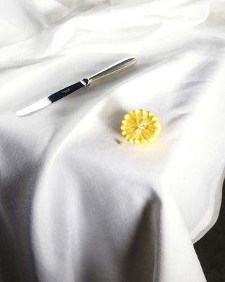 Knife and butter on white tablecloth