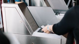 A passenger scanning their boarding pass at an airport e-gate