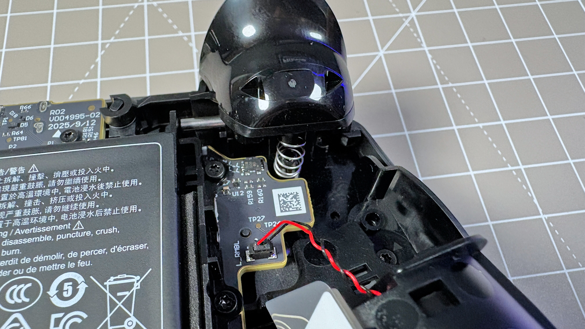 The Steam Controller on a desk during a teardown, with various parts removed.