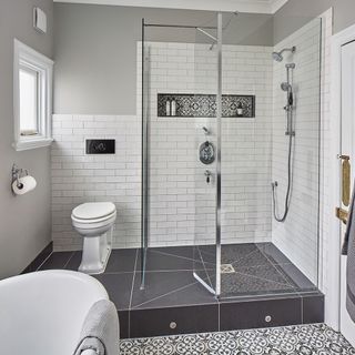 bathroom with white tiled walls and printed tiled flooring