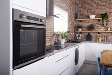 oven in a kitchen with exposed red brick walls 