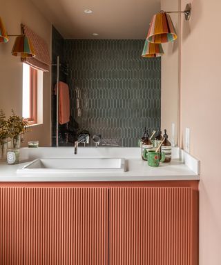 Small bathroom with red painted vanity and pink walls