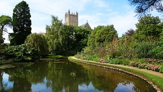 Lake in front of curving path with abbey in background