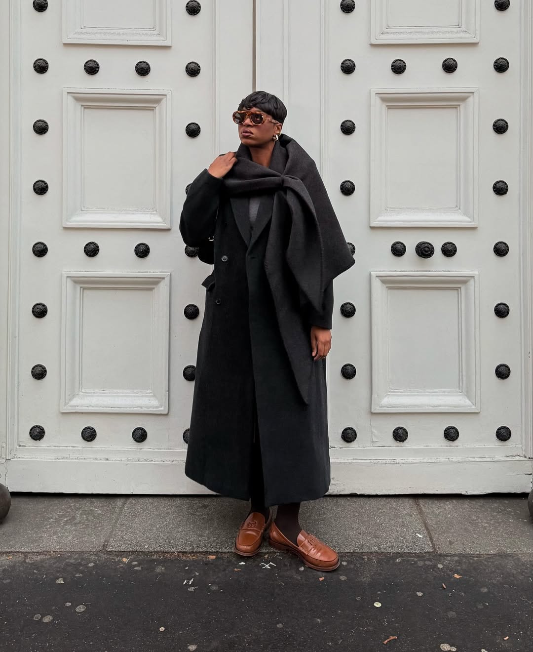 Grace in brown loafers and monochrome black outfit