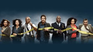 The Brooklyn Nine-Nine cast running towards the camera behind yellow police tape.