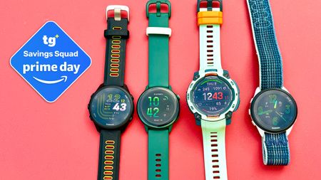 Close-up of the Garmin Instinct 3, Forerunner 165 Music, Forerunner 170, and Vivoactive 6 next to eachother on a red surface