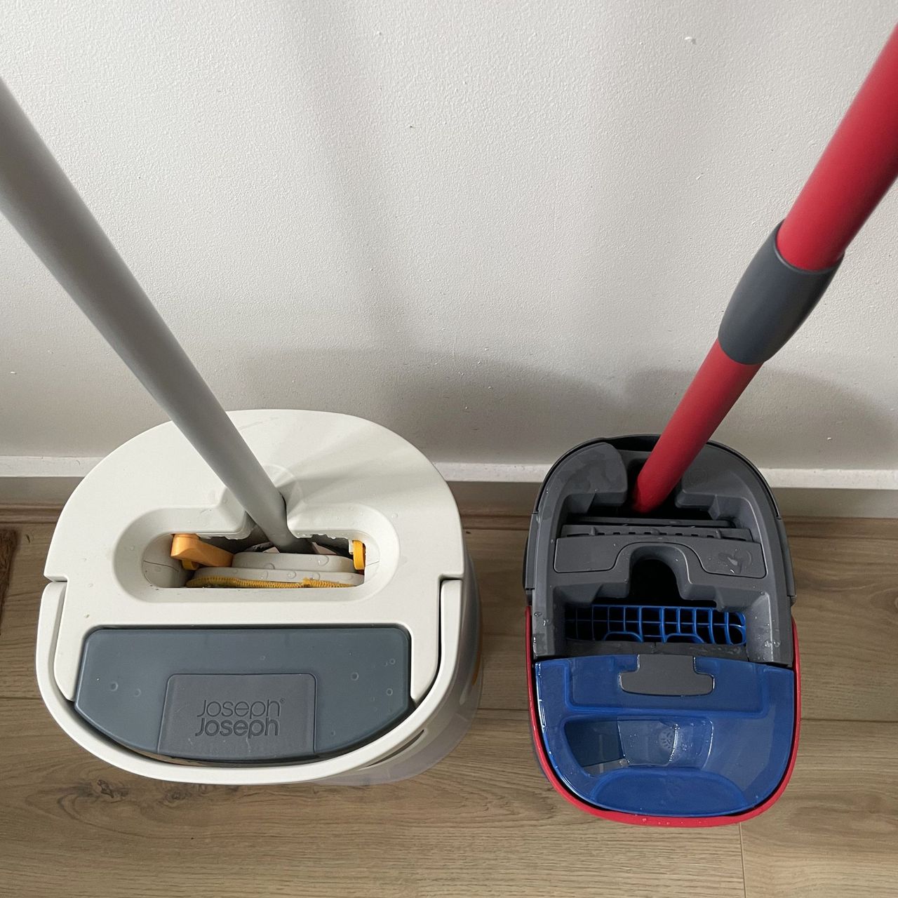Looking down at the top of the Joseph Joseph UltraClean mop sitting next to the Vileda h2pro mop and bucket