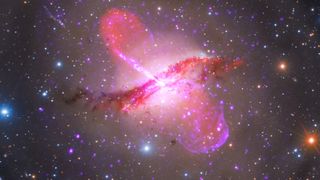 A multi-wavelength image of the stunning galazy Centaurus A, with twin lobes of purple light bursting out of its bright center