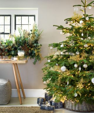Country home with large christmas tree, woven skirt, foliage on windowsill, wooden console table