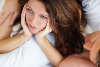 unhappy woman in bed with man