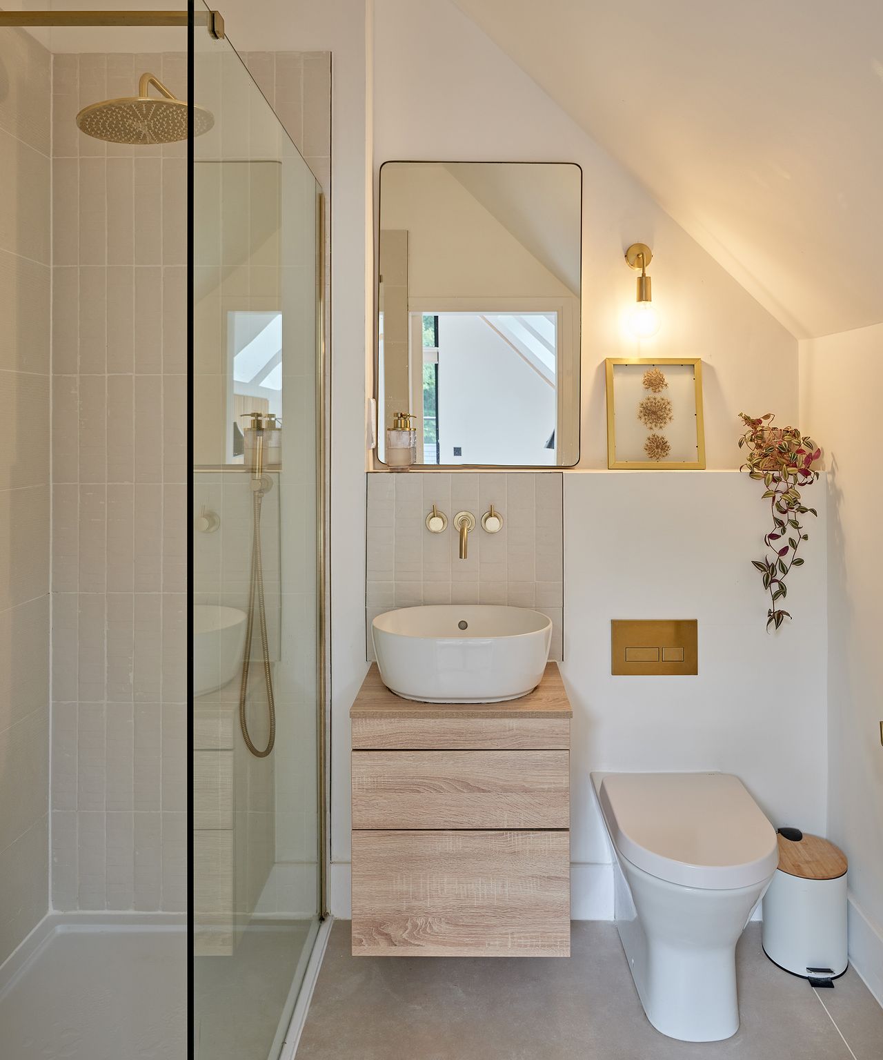 A light coloured en suite bathroom with shower and toilet