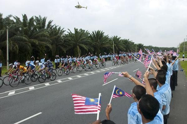 The peloton pass by many Malaysian students roadside during stage five of the 2011 Tour de Langkawi.