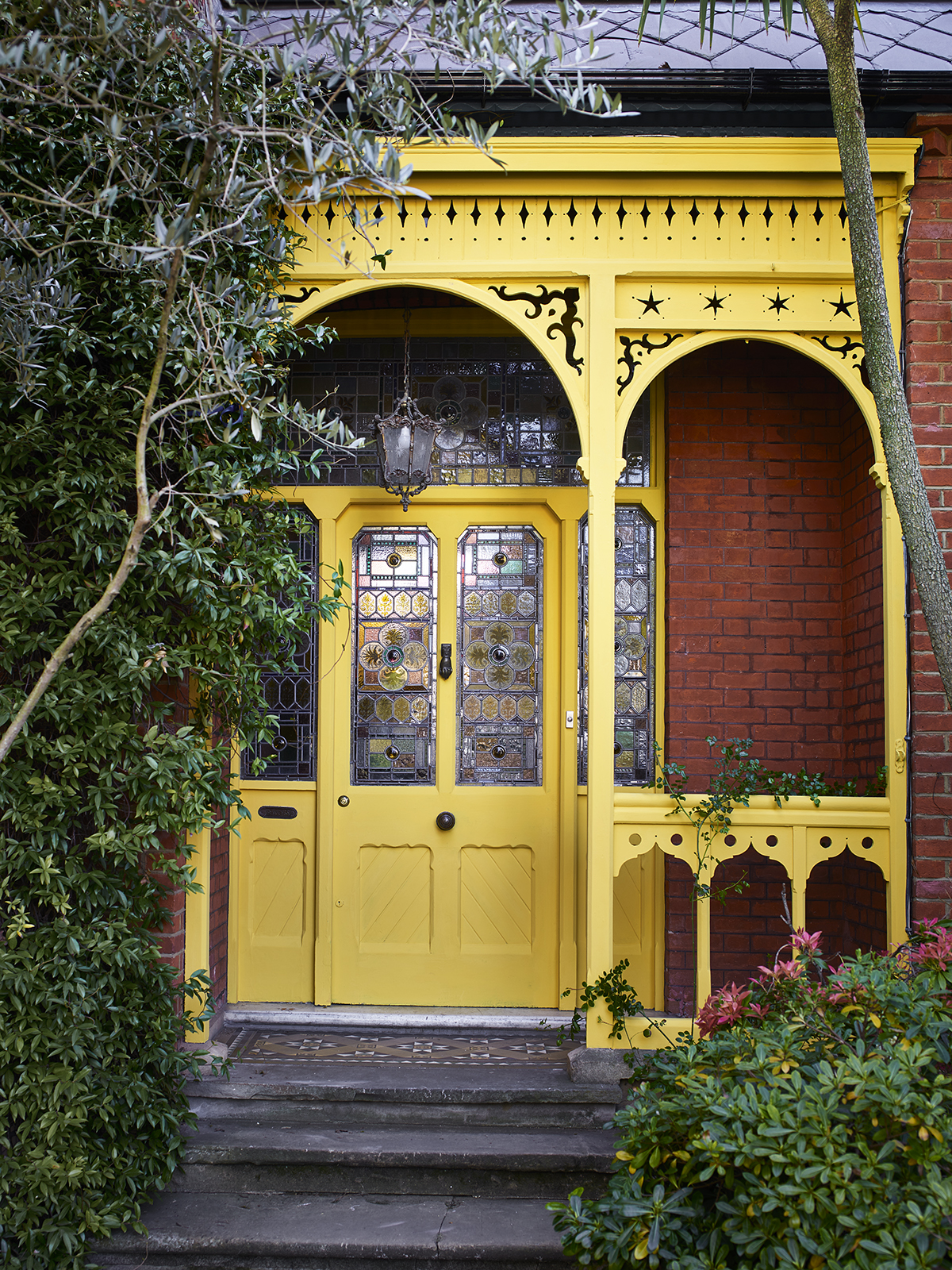 A front door and porch painted bright yellow front