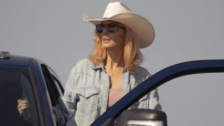 Kelly Reilly standing on a truck looking to her left.