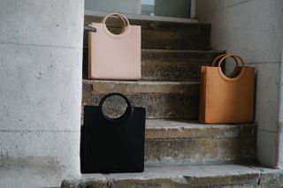 Leather bags sit on a concrete step