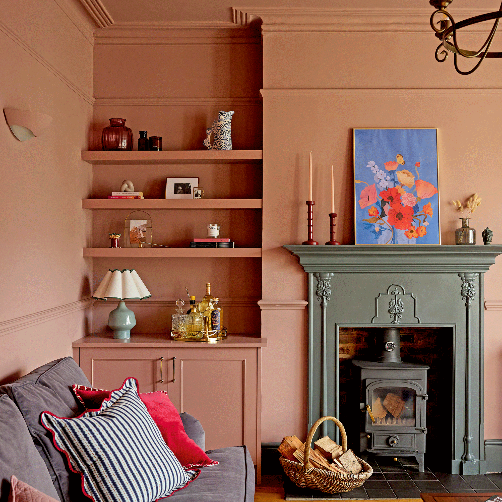 a pink colour-drenched living room with as green painted traditional fireplace