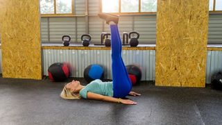 Woman performs leg raise core exercise