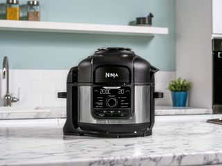 Ninja Foodi 9-in-1 Multi-Cooker on marble counter top in kitchen with turquoise wall