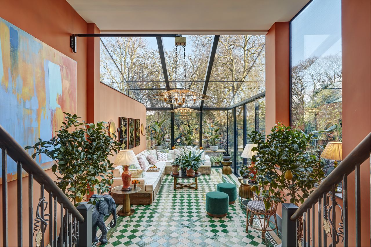 An orangery painted in a soft orange colour with green and white checkerboard tiled flooring