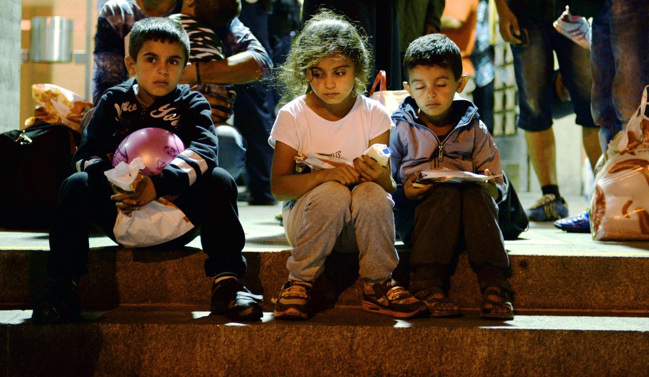 Migrant children sit on the steps of a German train station