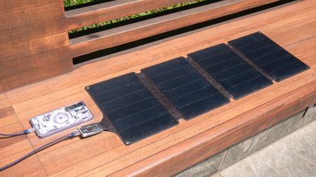 Duracell M-Series Portable Solar Panel charging a phone.