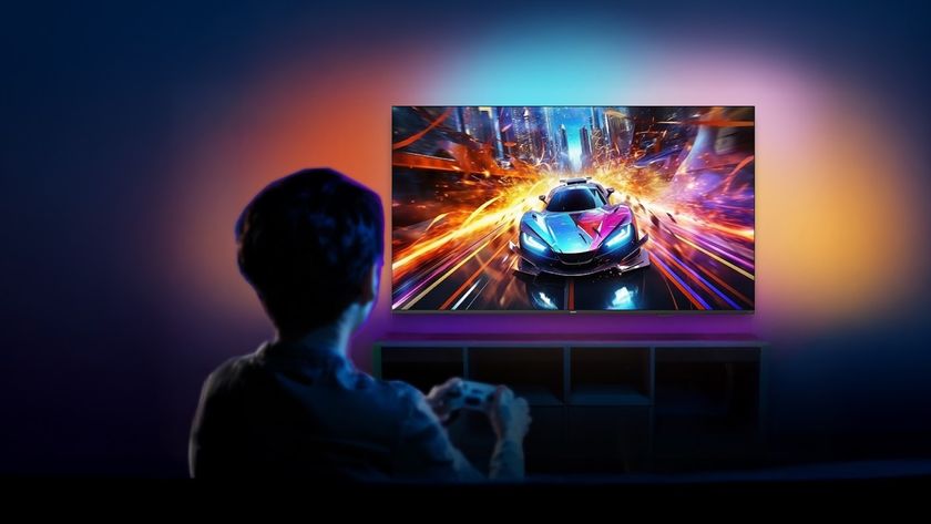 Lifestyle image of the Roku Philips Ambilight TV shot from behind someone playing a video game with a sports car in it and lots of colors on the wall