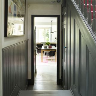 A grey hallway with wood panelling