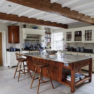 kitchen with white walls and tiles flooring and wooden counter with ceramic countertop