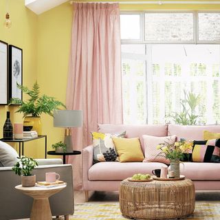 Yellow living room with pink sofa and curtains
