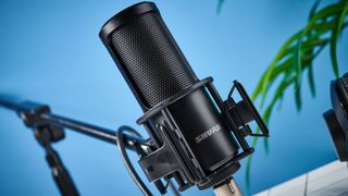 the Shure sm4 condenser musician microphone photographed against a blue background with a physical magnetic pop filter