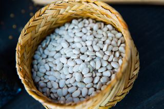 A wicker basket filled with dried white beans