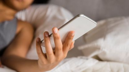 Woman scrolling on social media in bed