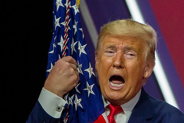 Trump hugs a flag at CPAC.