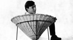 black and white photograph of terence conran on a wicker chair, from 1950s
