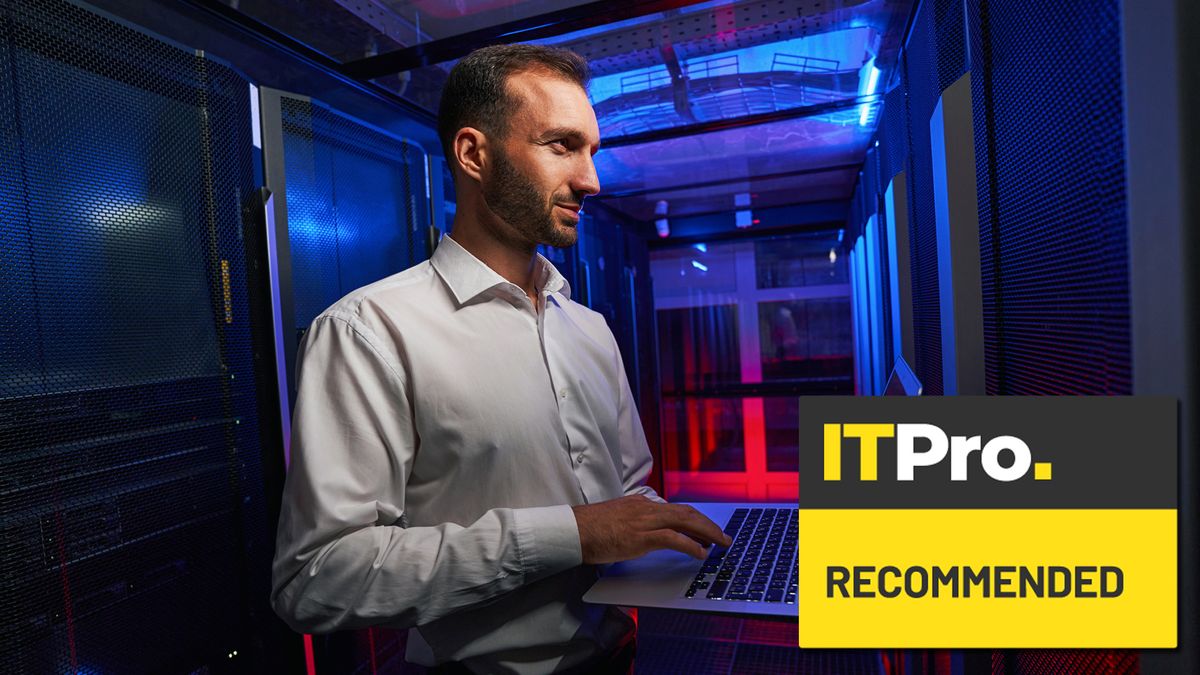 man working on computer in server room