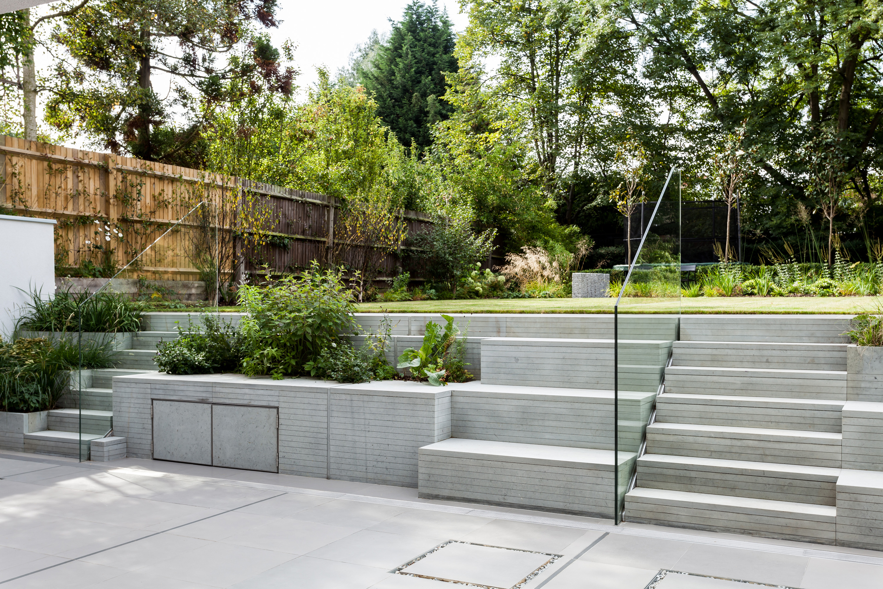 modern garden with paved steps leading up to a raised lawn