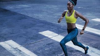 A photo of a woman running whilst wearing the fitbit ionic