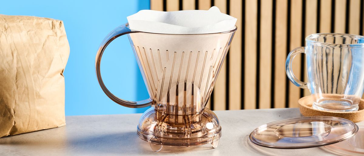 the clever dripper, a brown transparent plastic manual coffee maker with a handle and a sluice feature in the bottom to keep water inside