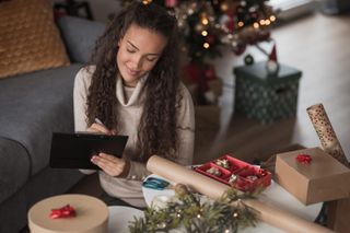 Woman writing her cards to make sure she doesn't miss the last Christmas post dates