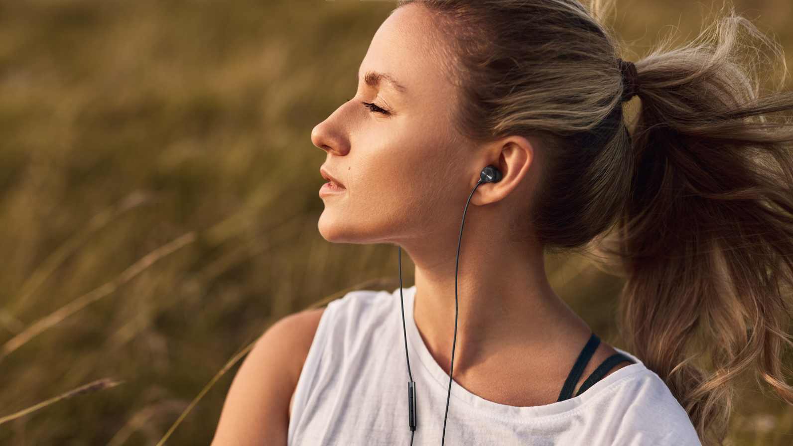 The Panasonic ErgoFit In-Ear in a woman's ears.