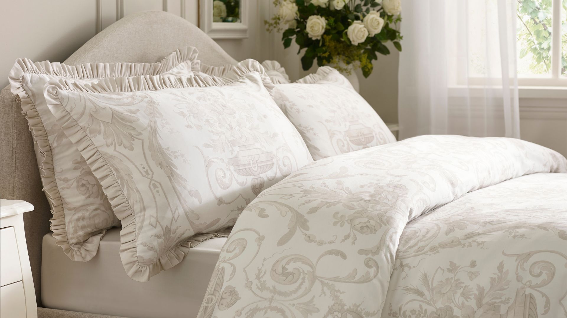 Dunelm Dorma Regency Bedding on a bed, in a room with flowers in the corner