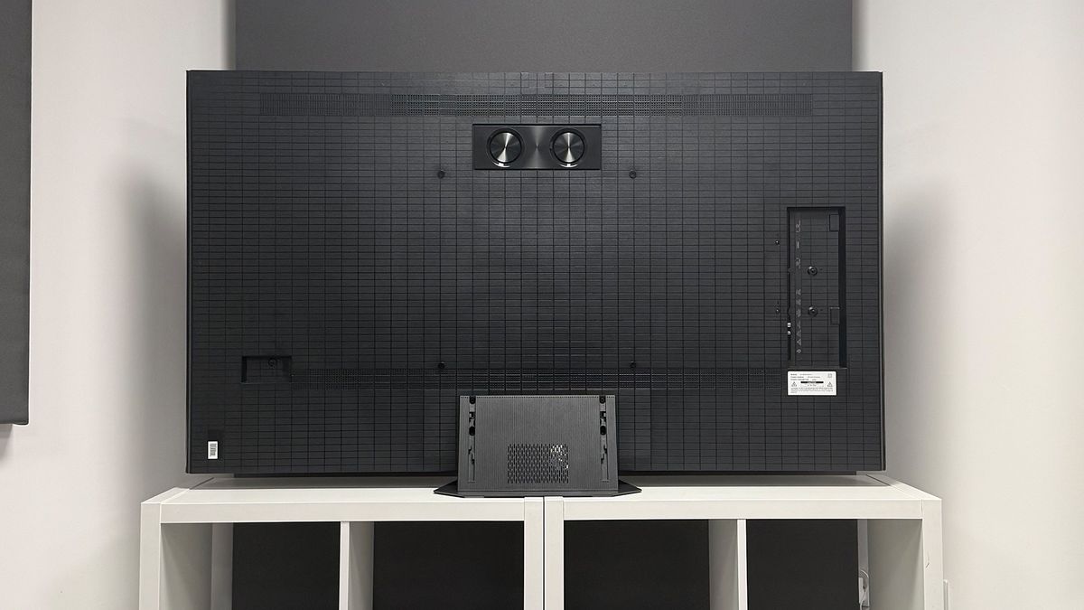 The 65-inch Hisense UR9 RGB Mini LED TV, photographed on a white, wooden unit. On the screen is a still from Netflix documentary, The Dinosaurs.