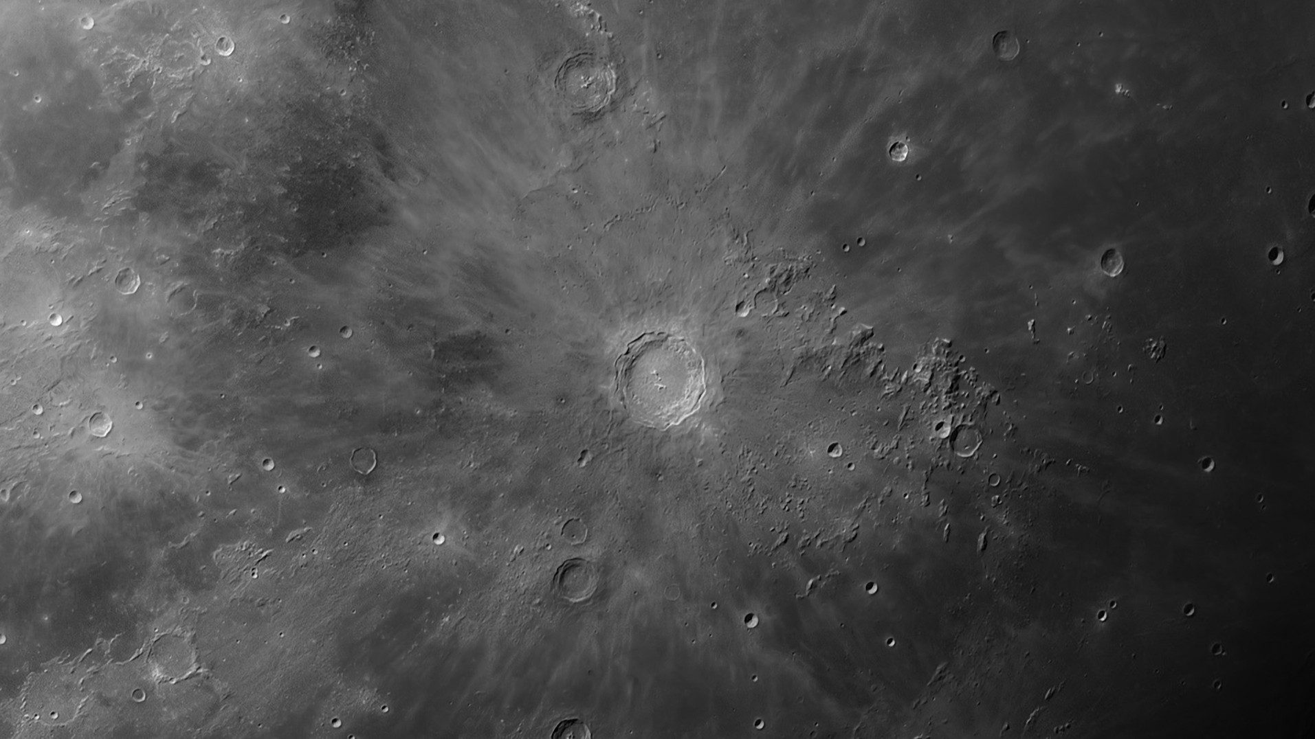 Close da cratera Copérnico na Lua, cercada por crateras menores.