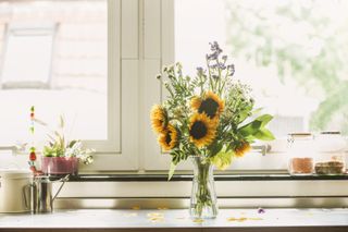 Summer flowers bunch with sunflowers on kitchen table