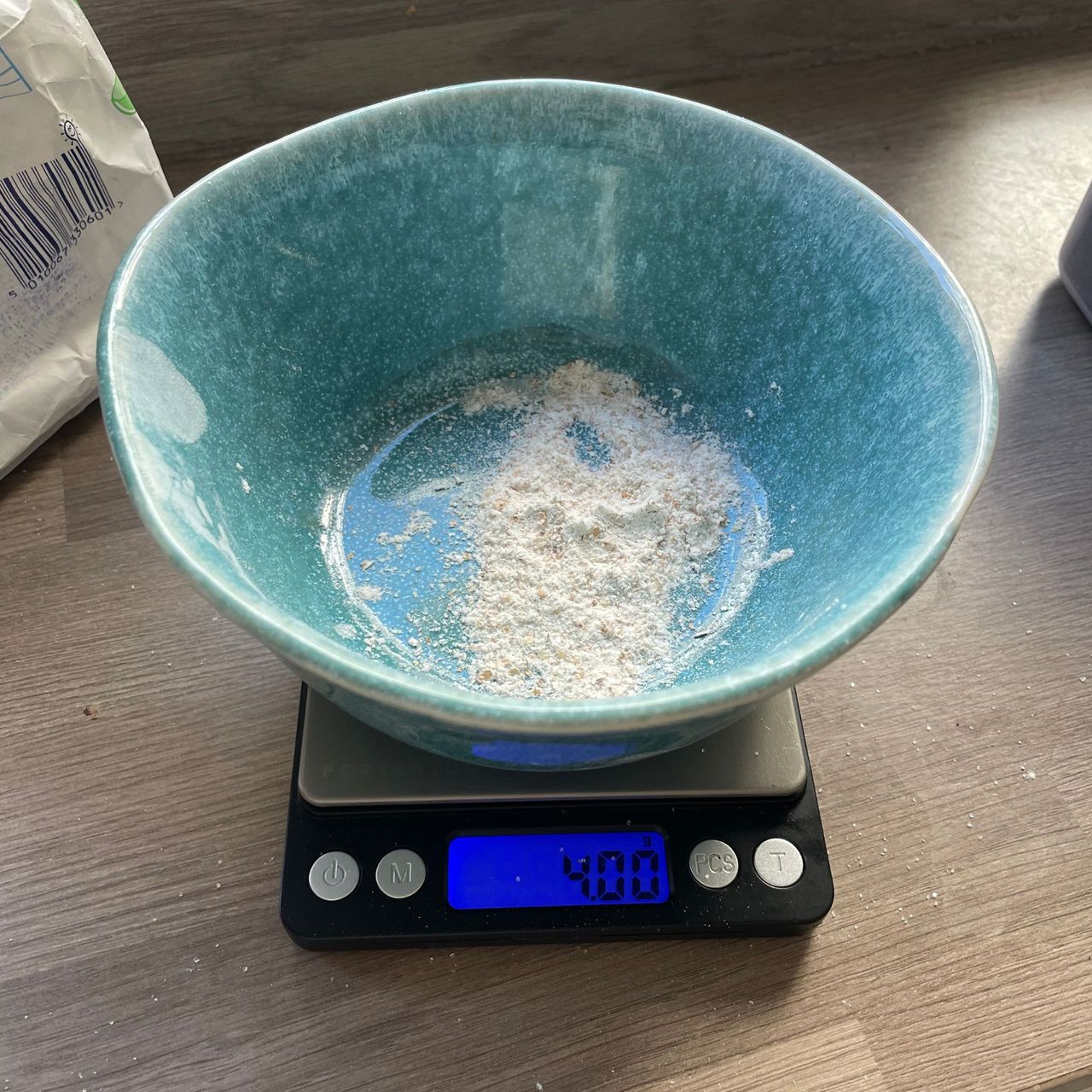 Blue bowl with flour in it, on a set of digital scales